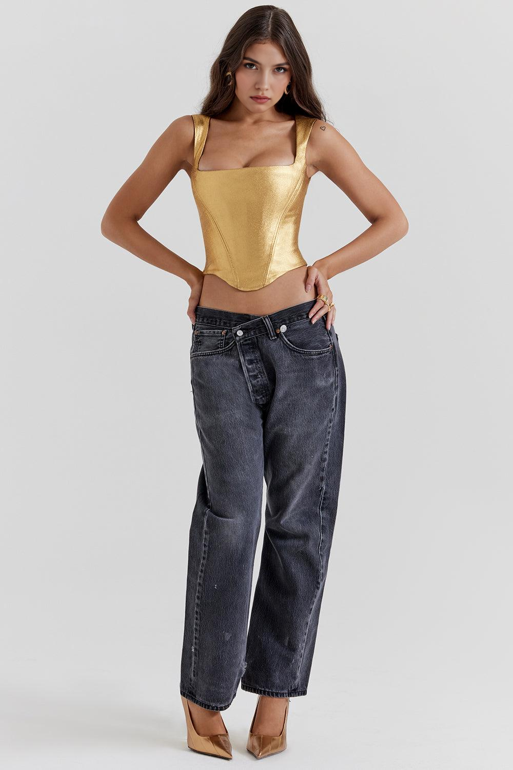 Corset feminino dourado com acabamento metalizado, alças largas e recorte acinturado, exibido em modelo com calça jeans.