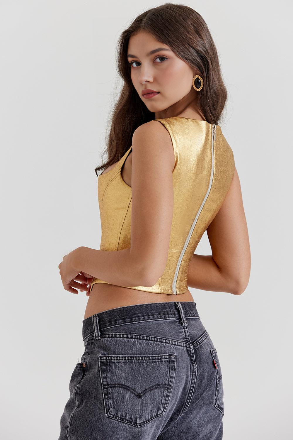 Corset feminino dourado com acabamento metalizado, alças largas e recorte acinturado, exibido em modelo com calça jeans.