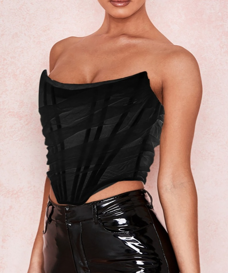 Modelo feminina vestindo corset estruturado com camadas de tule translúcido e acabamento drapeado em diagonal. Modelagem tomara que caia com recorte em V na barra. Estética moderna e elegante, ideal para composições ousadas e sofisticadas.