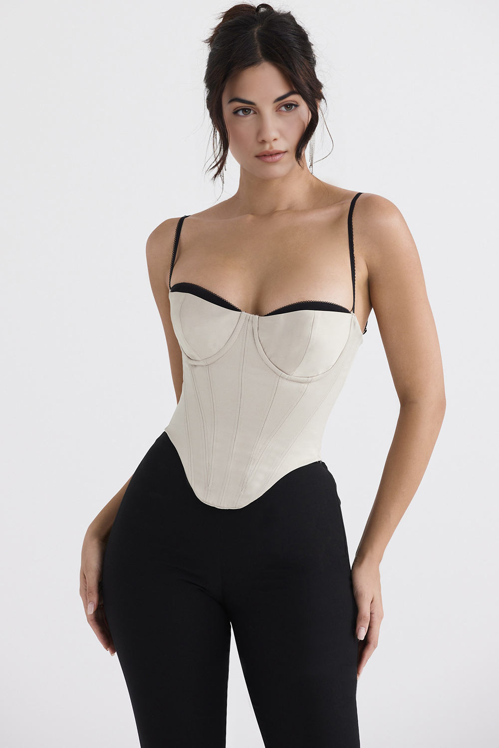 Imagem do Corset Modelador Cosmopolitan com estrutura em off-white, detalhes pretos no busto, barbatanas frontais e zíper traseiro. A peça realça o colo e define a cintura com elegância, combinando design sofisticado e funcionalidade.