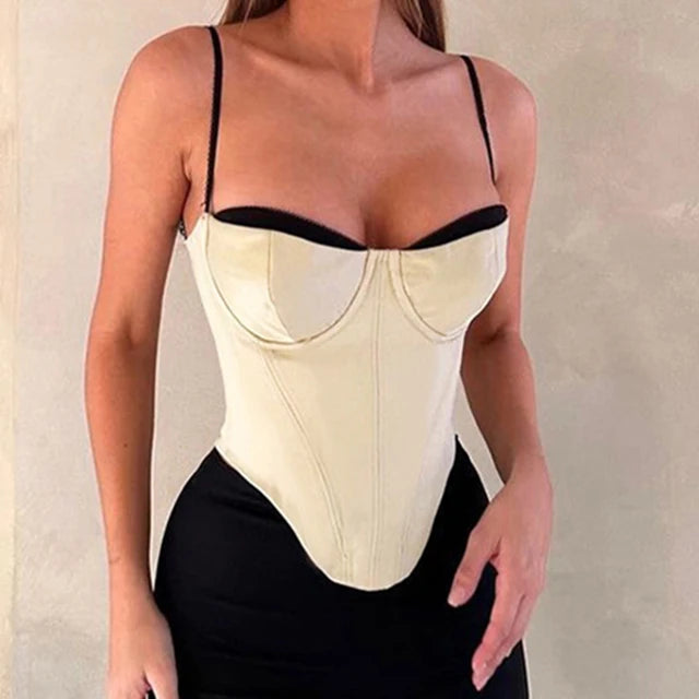 Imagem do Corset Modelador Cosmopolitan com estrutura em off-white, detalhes pretos no busto, barbatanas frontais e zíper traseiro. A peça realça o colo e define a cintura com elegância, combinando design sofisticado e funcionalidade.