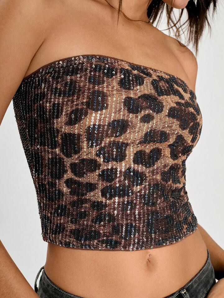 Top tomara que caia com estampa animal print e aplicação de paetês por toda a peça. Estrutura justa e modelagem reta, com brilho que destaca a silhueta em produções noturnas e ousadas. Estética impactante e sensual.