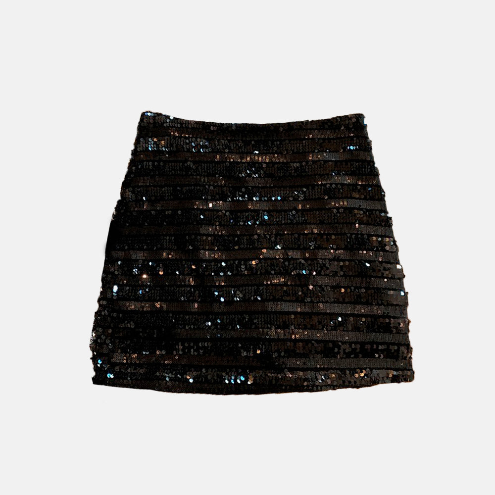 Saia feminina em tecido estruturado com textura listrada e aplicação de brilho discreto. Disponível em três cores, possui modelagem reta e caimento elegante. Ideal para ocasiões especiais ou composições refinadas do dia à noite.