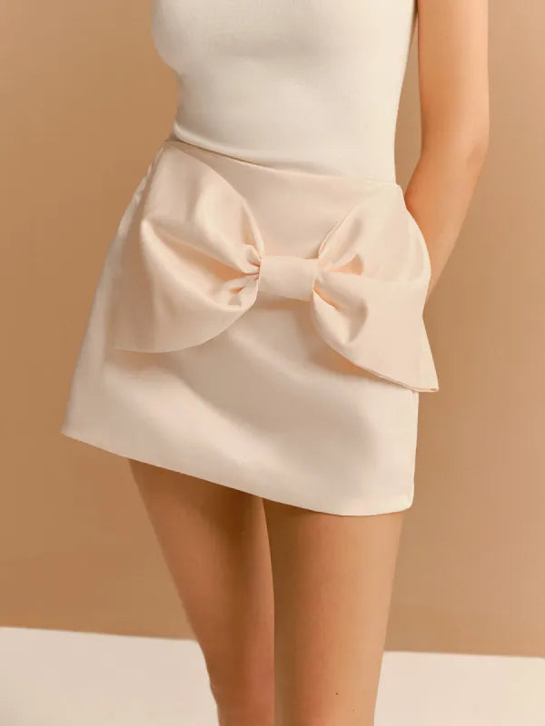 Saia de tecido estruturado com modelagem reta e laço frontal gigante aplicado na cintura. Peça de cintura alta, com visual romântico, feminino e elegante, ideal para composições sofisticadas ou ocasiões especiais.