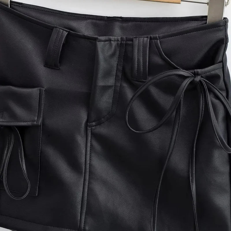 Saia em couro sintético com caimento estruturado, modelagem reta e cintura média. Bolsos utilitários com lapela, tiras ajustáveis nas laterais e passantes largos. Visual urbano, moderno e cheio de atitude.