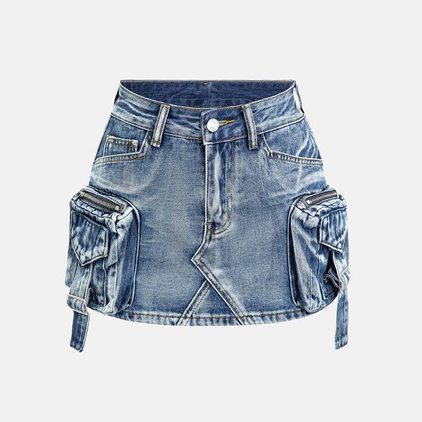 Modelo feminina vestindo saia jeans mini com bolsos cargo laterais volumosos, detalhes em zíper e amarração. A peça possui lavagem azul estonada e recortes assimétricos, com estilo urbano, ajustado e visual utilitário moderno.