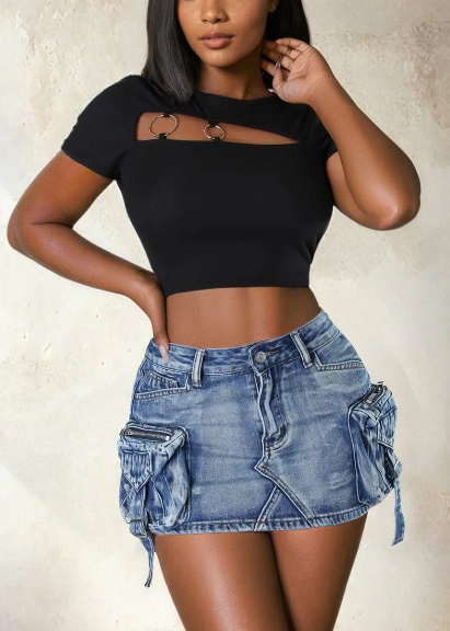 Modelo feminina vestindo saia jeans mini com bolsos cargo laterais volumosos, detalhes em zíper e amarração. A peça possui lavagem azul estonada e recortes assimétricos, com estilo urbano, ajustado e visual utilitário moderno.