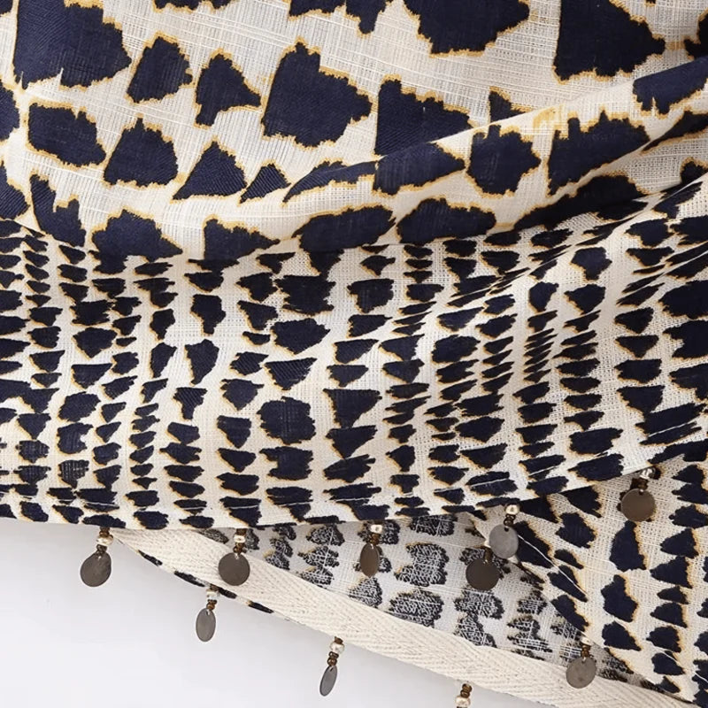 Saia feminina transpassada com estampa tribal, amarração frontal ajustável e aplicação de pompons na barra. Caimento leve, tecido fluido e cintura baixa, ideal para composições tropicais, boho chic ou looks de verão com atitude.