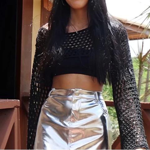 Saia mini metalizada em material sintético com acabamento espelhado. Modelagem ajustada com cós tradicional, bolsos e recorte central. Ideal para looks noturnos ousados, baladas e produções com brilho e atitude.