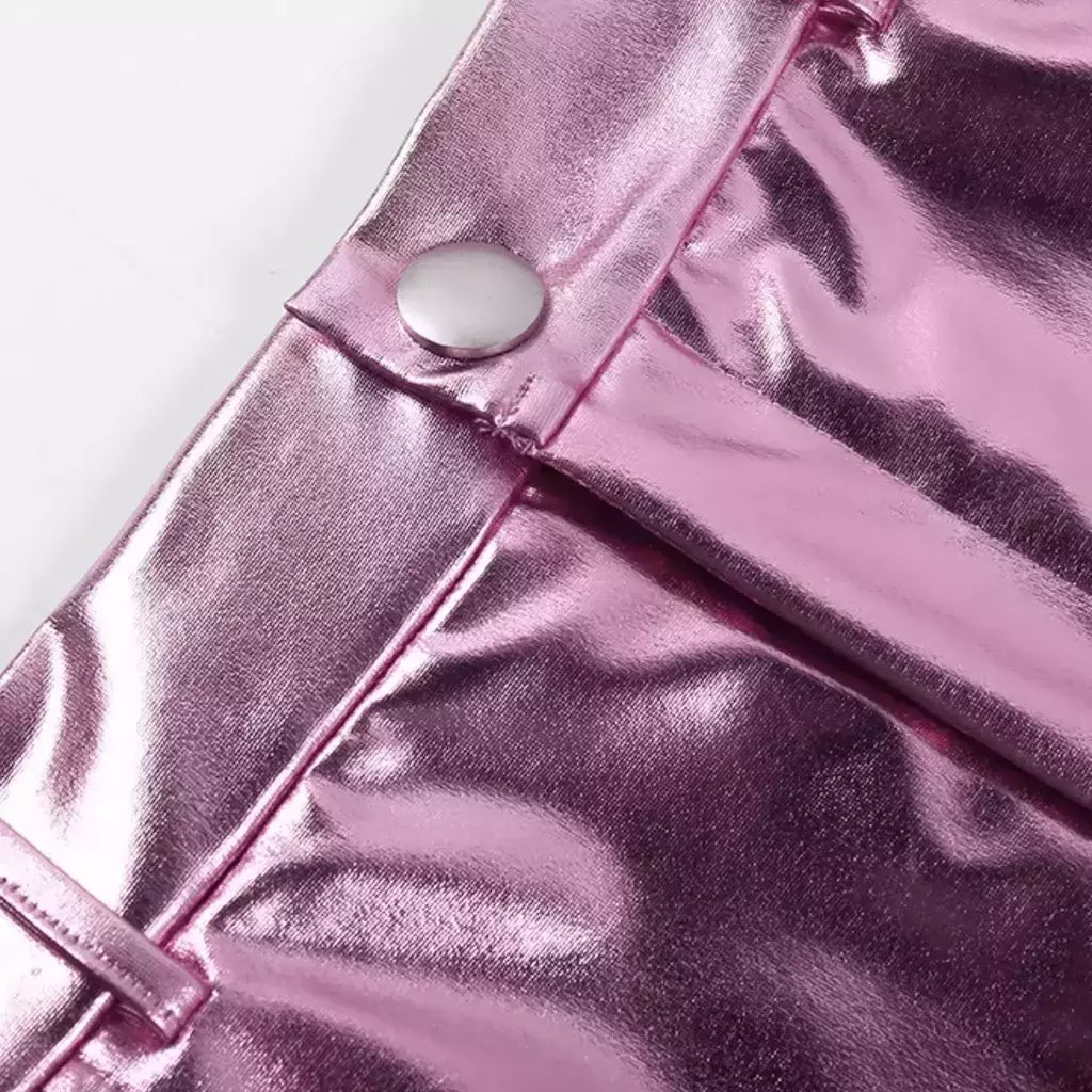 Saia mini metalizada em material sintético com acabamento espelhado. Modelagem ajustada com cós tradicional, bolsos e recorte central. Ideal para looks noturnos ousados, baladas e produções com brilho e atitude.